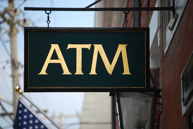 Exterior business ATM sign with American flag in background
